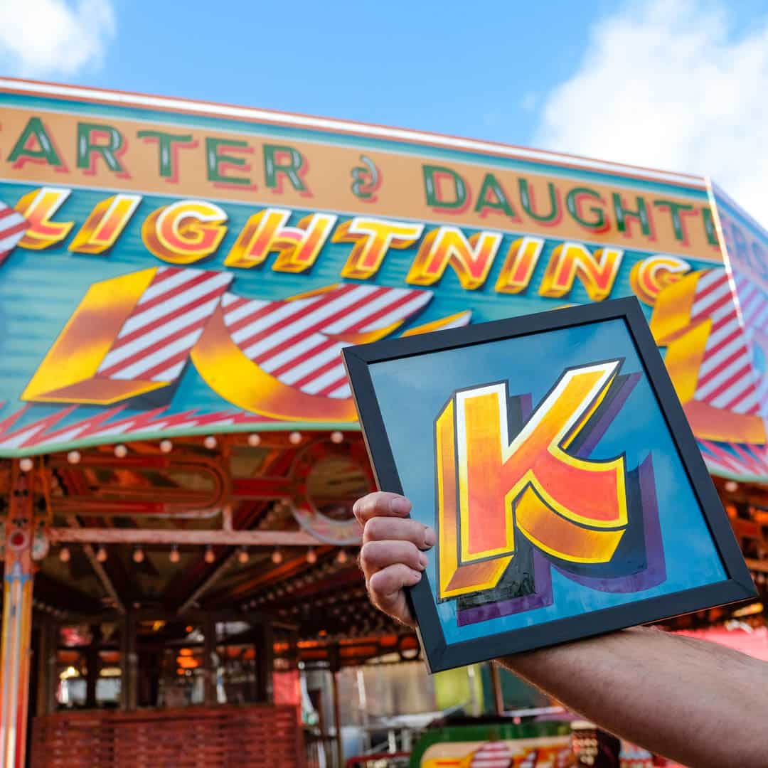 Joby Carter hand painted alphabet letter next to Lightning skid ride