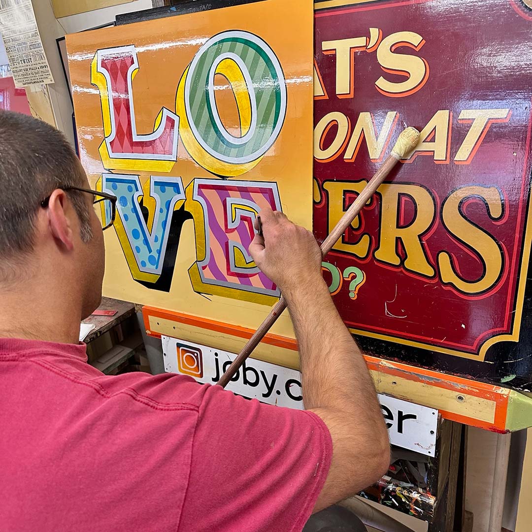 Joby Carter painting LOVE sign