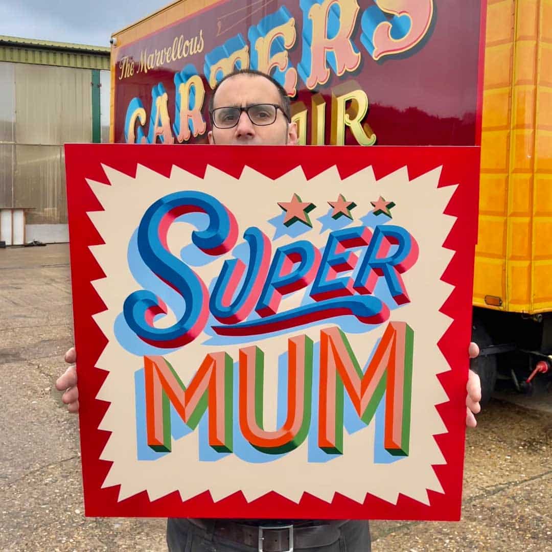Joby Carter holding original sign of Supermum lettering