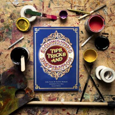 Joby Carters book signwriting tips tricks and inspiration surrounded by signwriting supplies