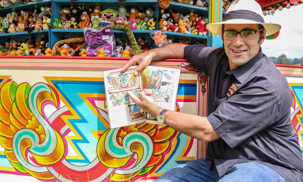 Joby Carter with his signwriting book next to the Hoopla Stall