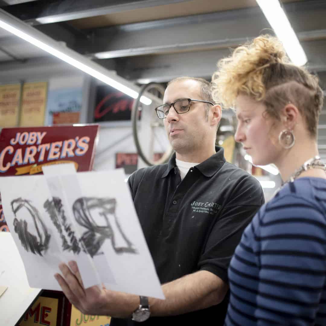 Joby Carter with. student on one of his signwriting courses