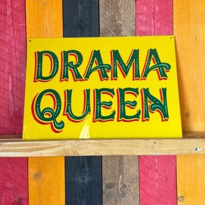 Yellow and Green hand painted sign that reads Drama Queen