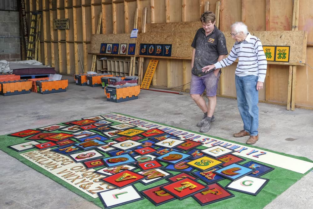 Aaron and stan looking at hand painted letters for all the fonts of the fair