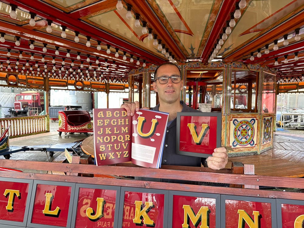 Joby Carter with hand painted letters (Howellphabet) on the Lightning Skid ride at Carters Steam Fair